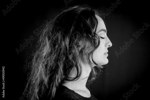 Black and white portrait of a beautiful young Italian woman with very long brown hair in profile with closed eyes
