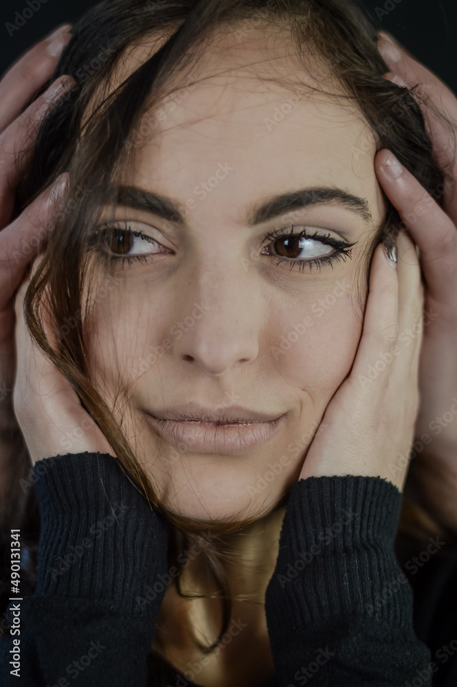 Close up portrait of a beautiful young woman with her cheeks covered with hands - concept of worries, fears and anxiety Close up portrait of a beautiful young woman with her cheeks covered with hands - concept of worries, fears and anxiety