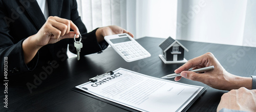 Estate agent giving house and keys to client after signing agreement contract real estate with approved mortgage application form for or house insurance