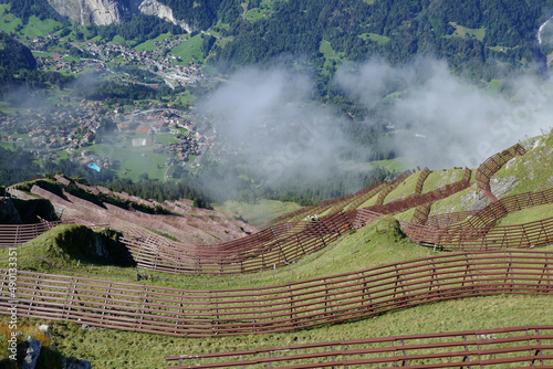 Obraz na plátně Snow fences on a mountainous landscape with a village in Wengen, Switzerland