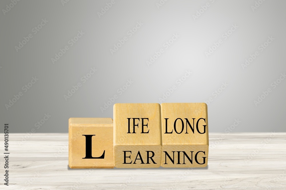 Lifelong learning symbol. Turned wooden cubes for concept words. Business, educational and lifelong learning concept.