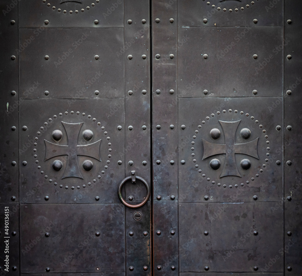 old metal door with knocker and christian symbols