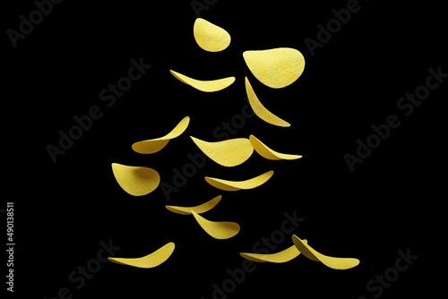 Crispy potato chips flying in the air. On an black background. Fast food.