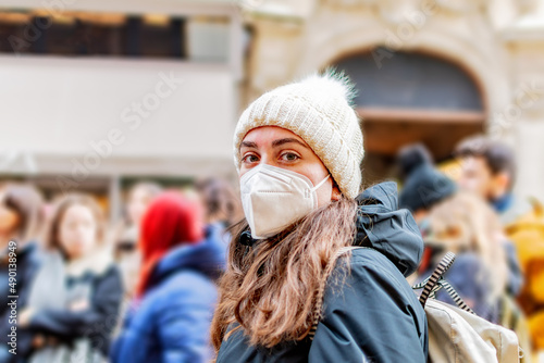 Close-up portrait of young white woman with protective mask on blur background.