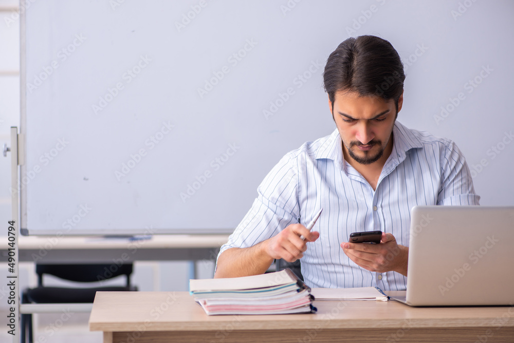 Young male teacher in front of whiteboard