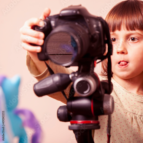  Little cute child girl photographer is taking a photo. © zwiebackesser