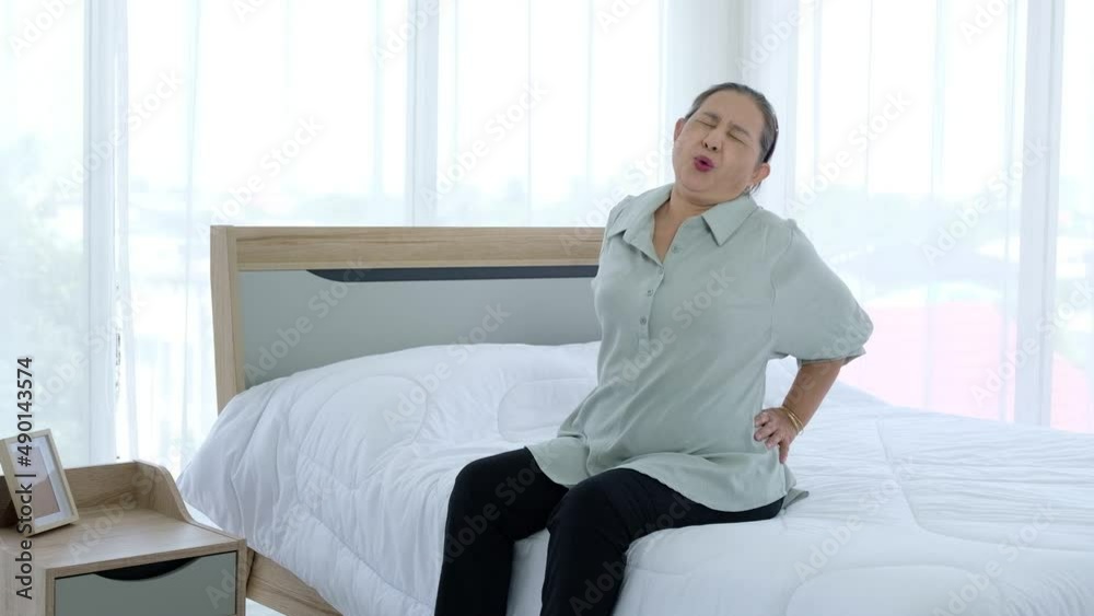 Senior woman suffering from back pain after sleeping on uncomfortable mattress at home. Senior woman suffering from back pain after sleeping on uncomfortable mattress at home.