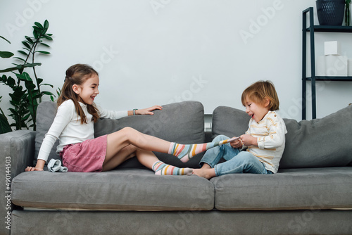 Fotografie Boy pulling off sock of a girl, they are preparing for a tickling competition