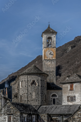 Vertical shot of the Church of Corippo on a mountain in autumn in Switzerland photo