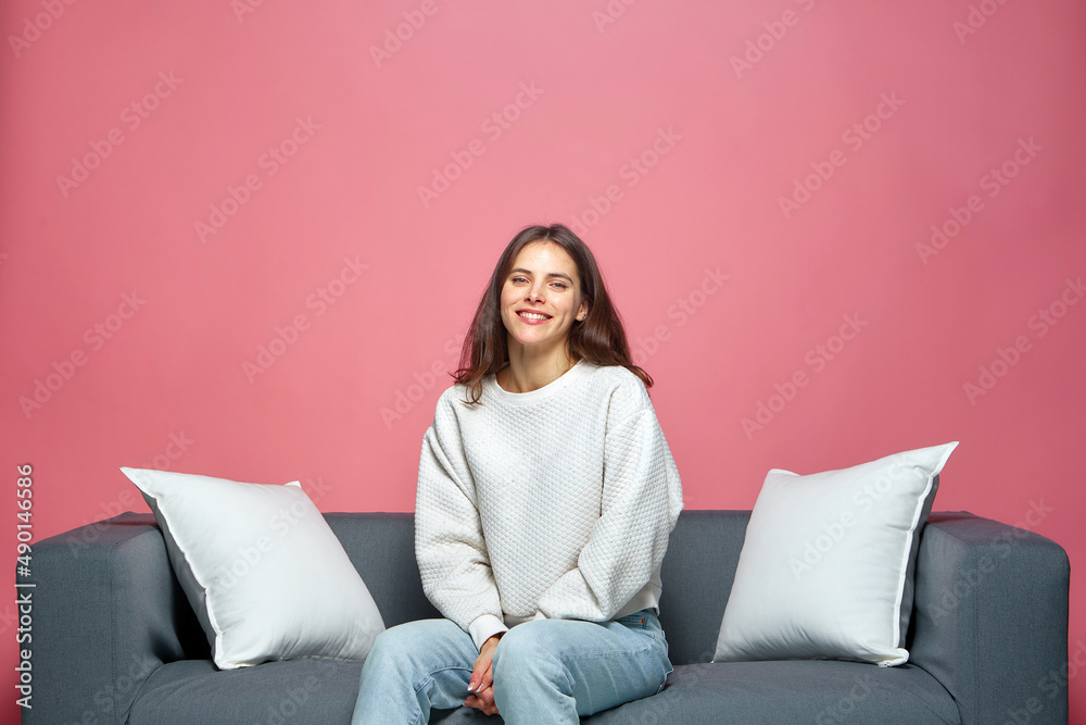 Happy overjoyed young girl sitting on sofa, smiling, satisfied with ordered goods or service, watching comedy stand-up Happy overjoyed young girl sitting on sofa, smiling, satisfied with ordered goods or service, watching comedy stand-up