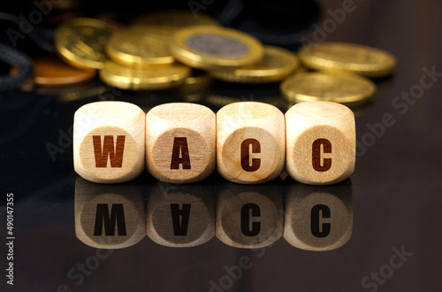 On a black surface are coins and cubes with the inscription - WACC photo