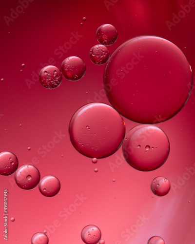 Composition of big and small colored circles oil drops on water.