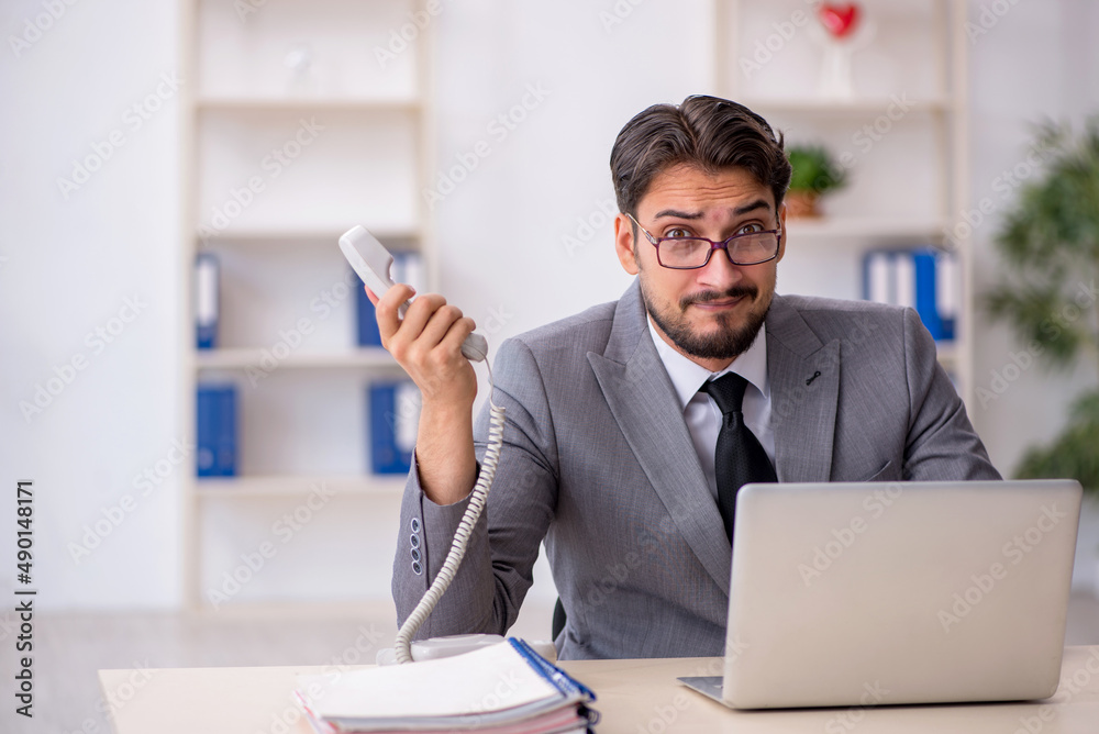 Young male employee working in the office Young male employee working in the office