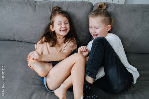 фотографія Two kids having a good time, trying to tickle each other's feet.