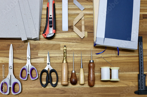 Photography Flat lay of tools used in bookbinding process on a wooden table