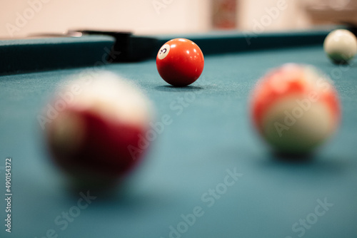 Shallow focus shot of red and white billiard balls on a billiard table.