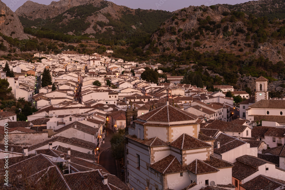 Panoramic view of the beautiful andalusian illuminated white town of Grazalema among mountains at sunrise, Cadiz, Andalusia, Spain