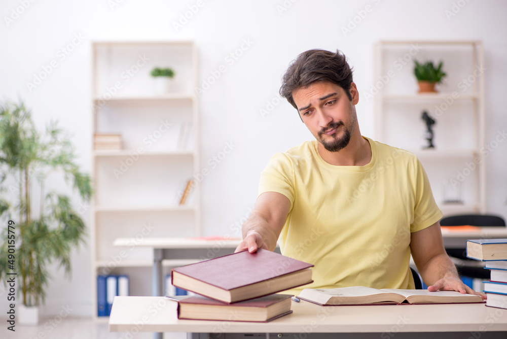 Young male student preparing for exams in the classroom Young male student preparing for exams in the classroom