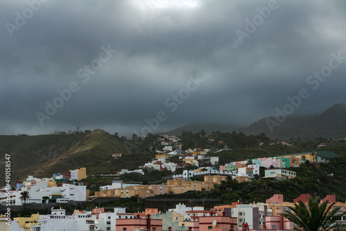 Scenic view on volcanic mountain valley and typical house facades of village town in La Palma (Canary Islands, Spain). Moody, cloudy and foggy panoramic countryside landscape. © Olga