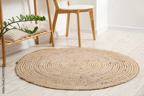 Wicker rug on light wooden floor in room