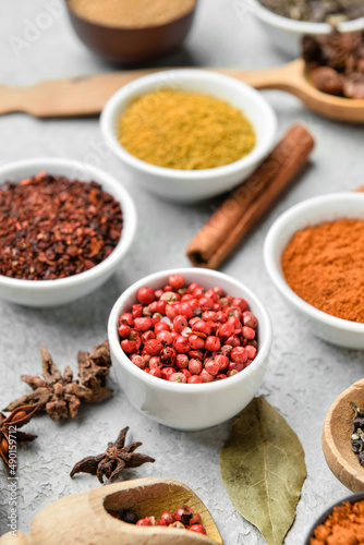 Bowls with aromatic spices on light background