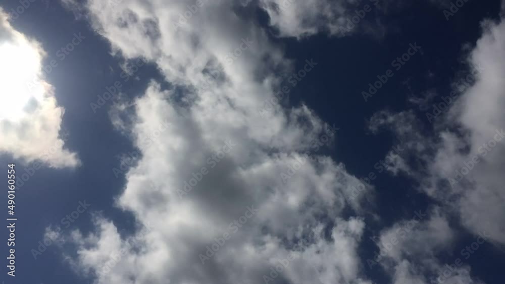 Clouds move quickly across the blue sky. Summer sunny day, the bright sun shines, under it white-gray clouds quickly fly by. They change their shape and size on the fly. Clouds move quickly across the blue sky. Summer sunny day, the bright sun shines, under it white-gray clouds quickly fly by. They change their shape and size on the fly.