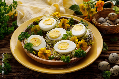 Canvas Print Easter hard-boiled eggs, divided into halves with herbs and sprout served with on a decorated plate, close up view