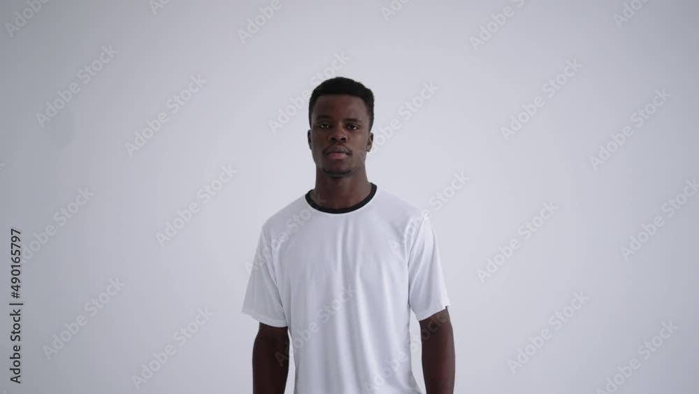 portrait of afro-american football player in white uniform posing in studio, holding ball by leg portrait of afro-american football player in white uniform posing in studio, holding ball by leg