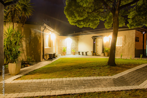 Beautiful exterior of a garden of a private house with grass, exotic plant and bright lights photo