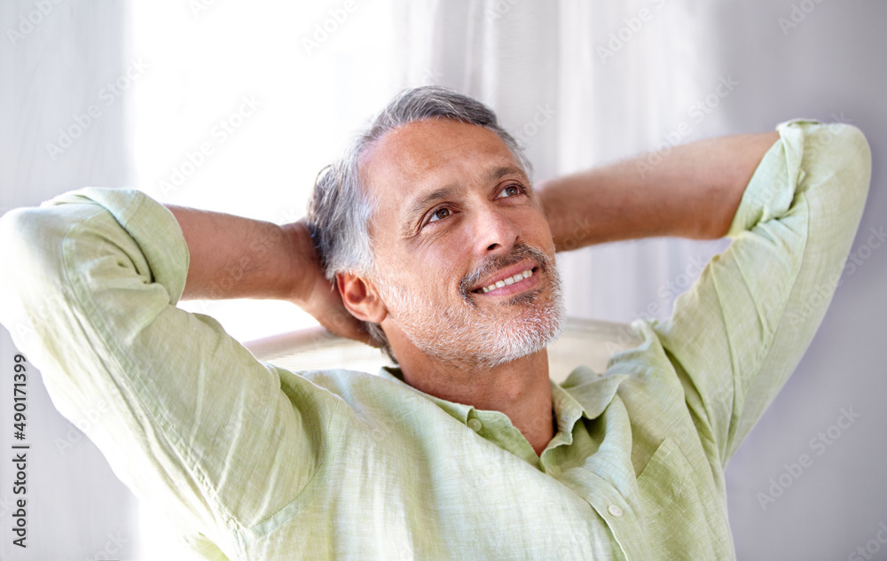 Laid-back. A mature man relaxing at home with his hands behind his head. Laid-back. A mature man relaxing at home with his hands behind his head.