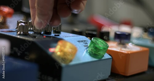 Musician Pressing Effect Pedal Then Adjusting Control Knobs. Close Up Effects Pedalboard. photo