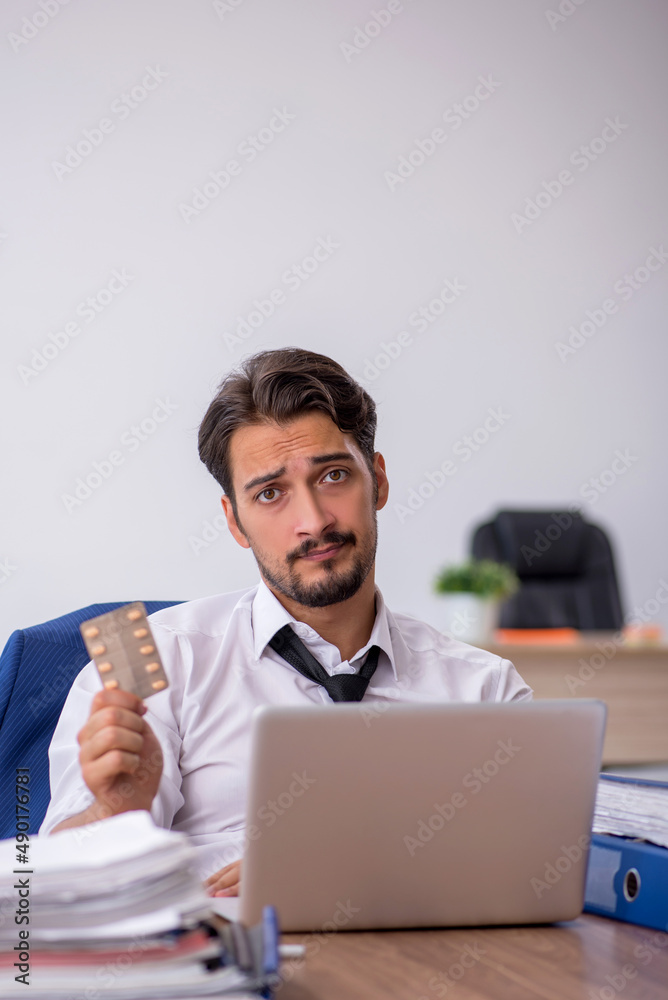 Young male employee and too much work in the office