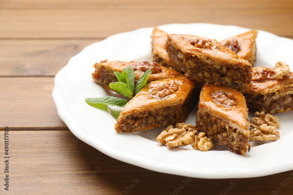 Delicious honey baklava with walnuts on wooden table, closeup