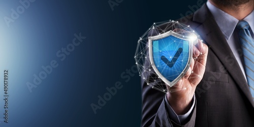 Businessman holds shield with a tick icon.Secure Access System Concept.Business Financial Warranty