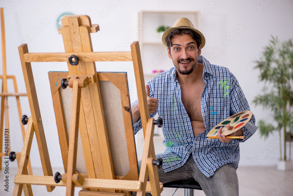 Young man enjoying painting at the studio Young man enjoying painting at the studio