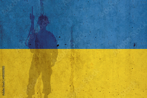 Ukraine flag on wall and shadow of soldier. Ukraine war concept