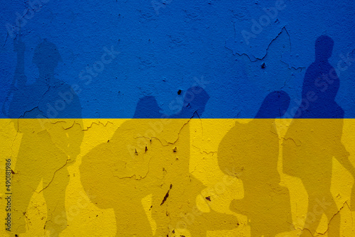 Obraz na plátne Ukraine flag on wall and shadows of soldier and refugees leaving