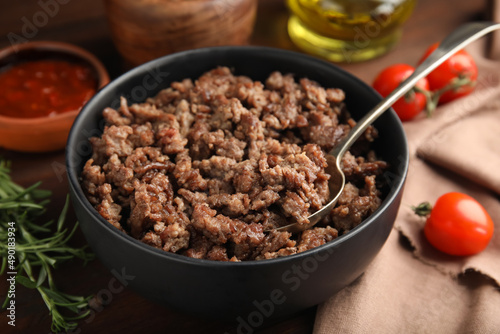 Fried minced meat and different products on wooden table, closeup