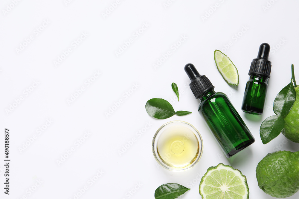 Bergamot essential oil and fresh fruits on white background, flat lay. Space for text Bergamot essential oil and fresh fruits on white background, flat lay. Space for text