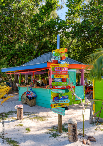 Colorful sign post in front of a tropical beach bar.