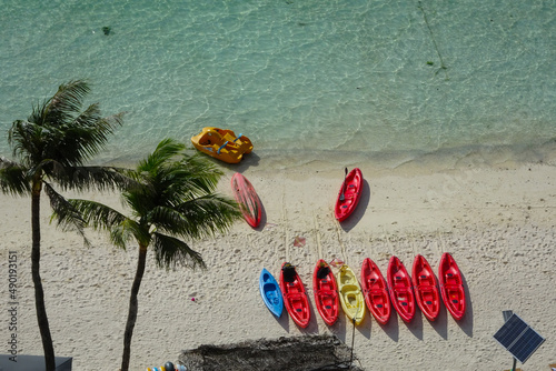 Foto Aerial view of coconut trees and colorful aligned Kayak Sailing boats on the Tum