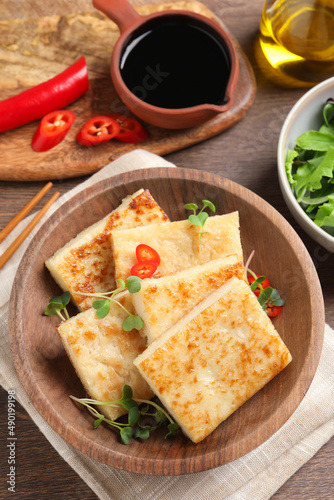 Delicious turnip cake with microgreens on wooden table, flat lay © New Africa