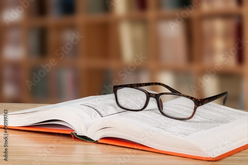 Old books, reading glasses on the wooden desk © BillionPhotos.com