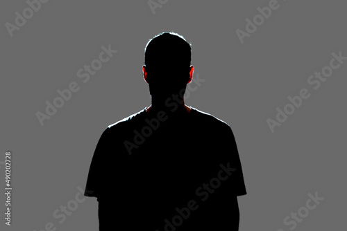 isolated dark male silhouette in the shadow, studio portrait photo
