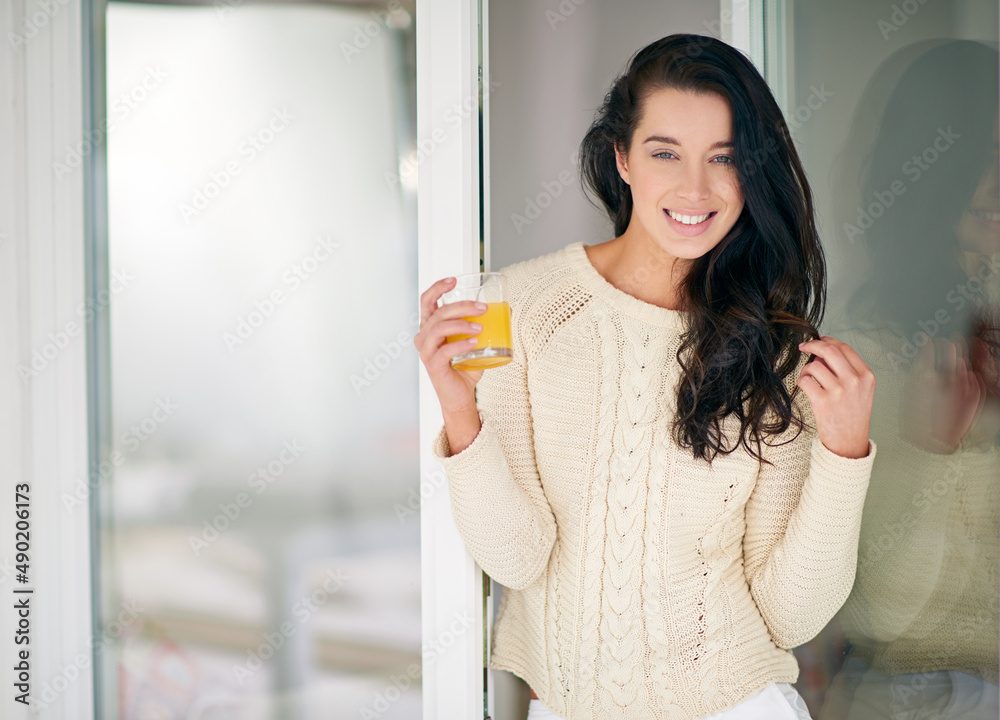 Enjoying a refreshing start to the day. Portrait of young woman drinking a glass of juice at home. Enjoying a refreshing start to the day. Portrait of young woman drinking a glass of juice at home.
