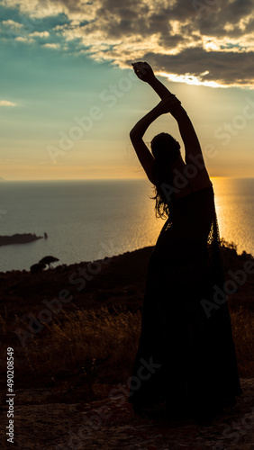 Silhouette of a beautiful woman enjoying her relaxation near Isola del Giglio, Italy photo