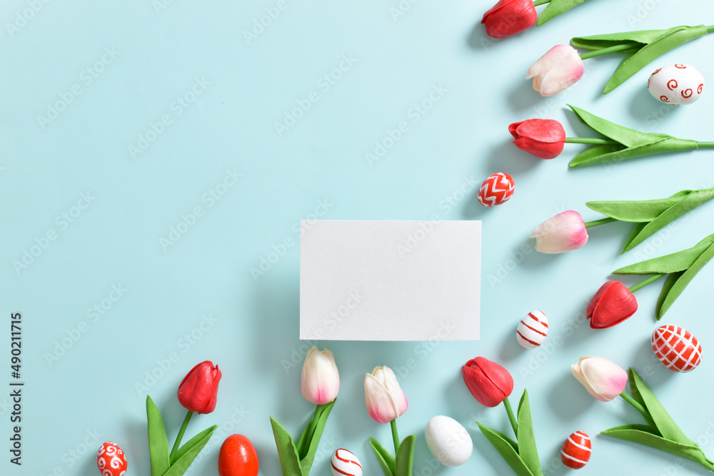 Background with tulips and Easter eggs with a blank sheet of paper.