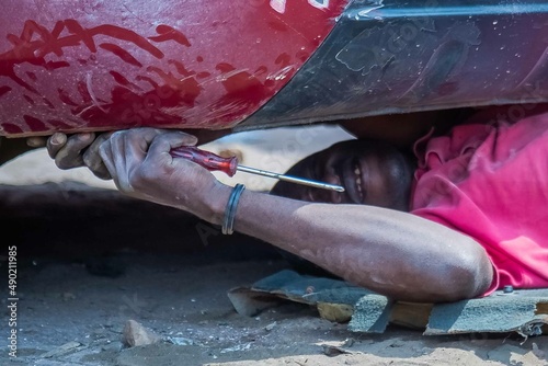 African Auto Bodyworks,  Welding a Car in Africa,  2 African men working on a car, African American auto mechanic at work, African American working with electrodes photo