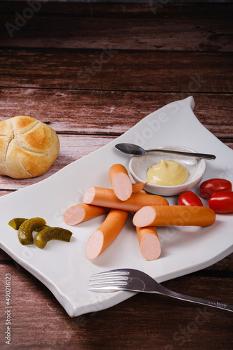 Vertical shot of a plate with frankfurter sausages and sides