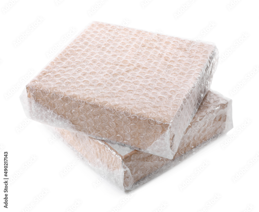 Cardboard boxes packed in bubble wrap on white background Cardboard boxes packed in bubble wrap on white background
